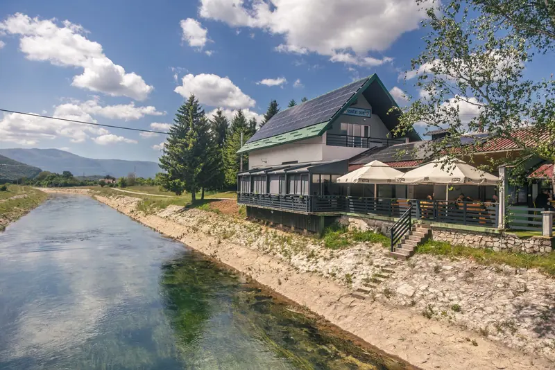 Restoran s terasom uz zelenu rijeku Gacku